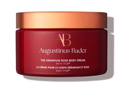 Red jar of Augustinus Bader body cream with a gold lid on a white background